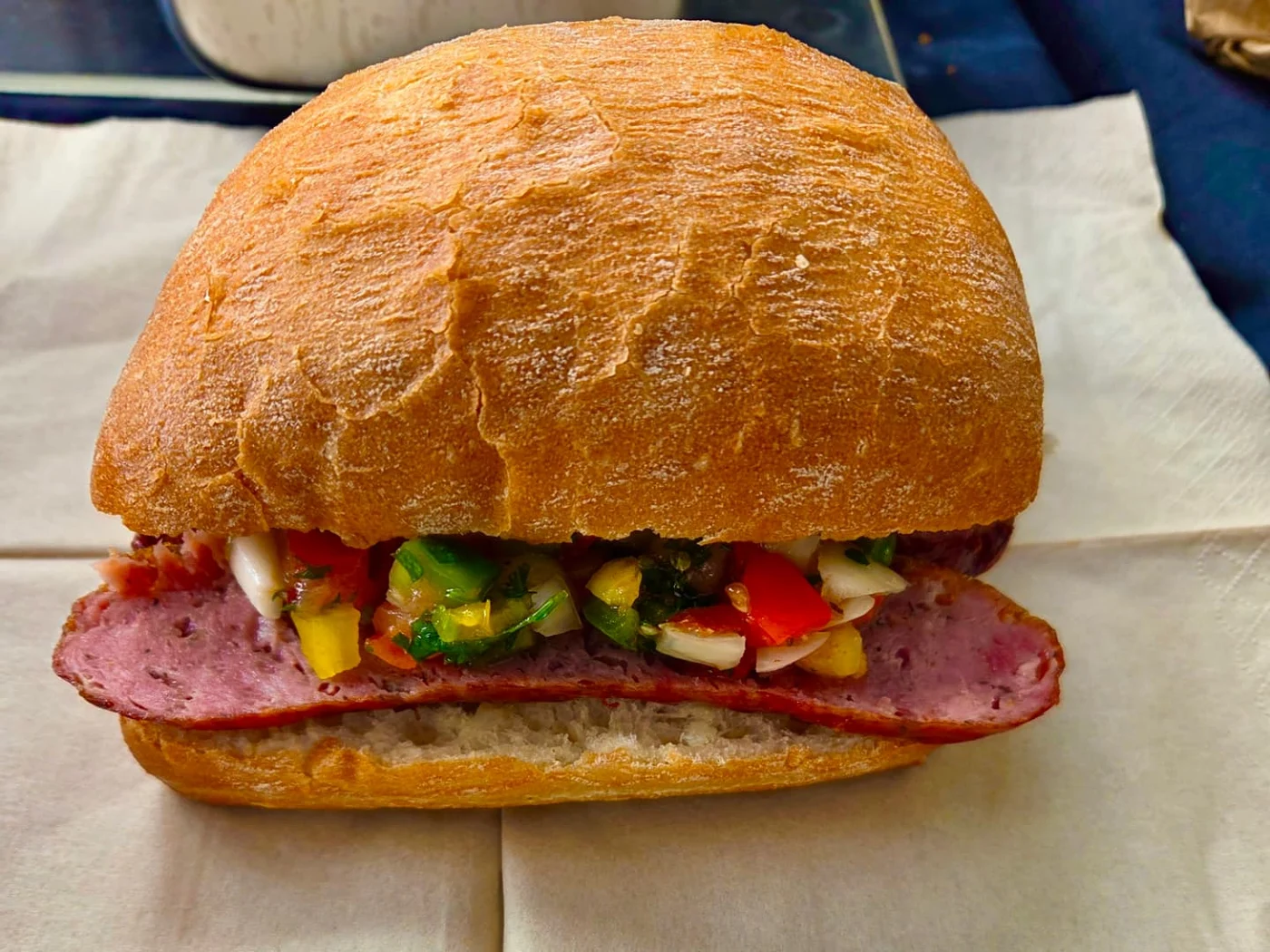 Choripán roll filled with Argentinian chorizo and fresh salsa criolla