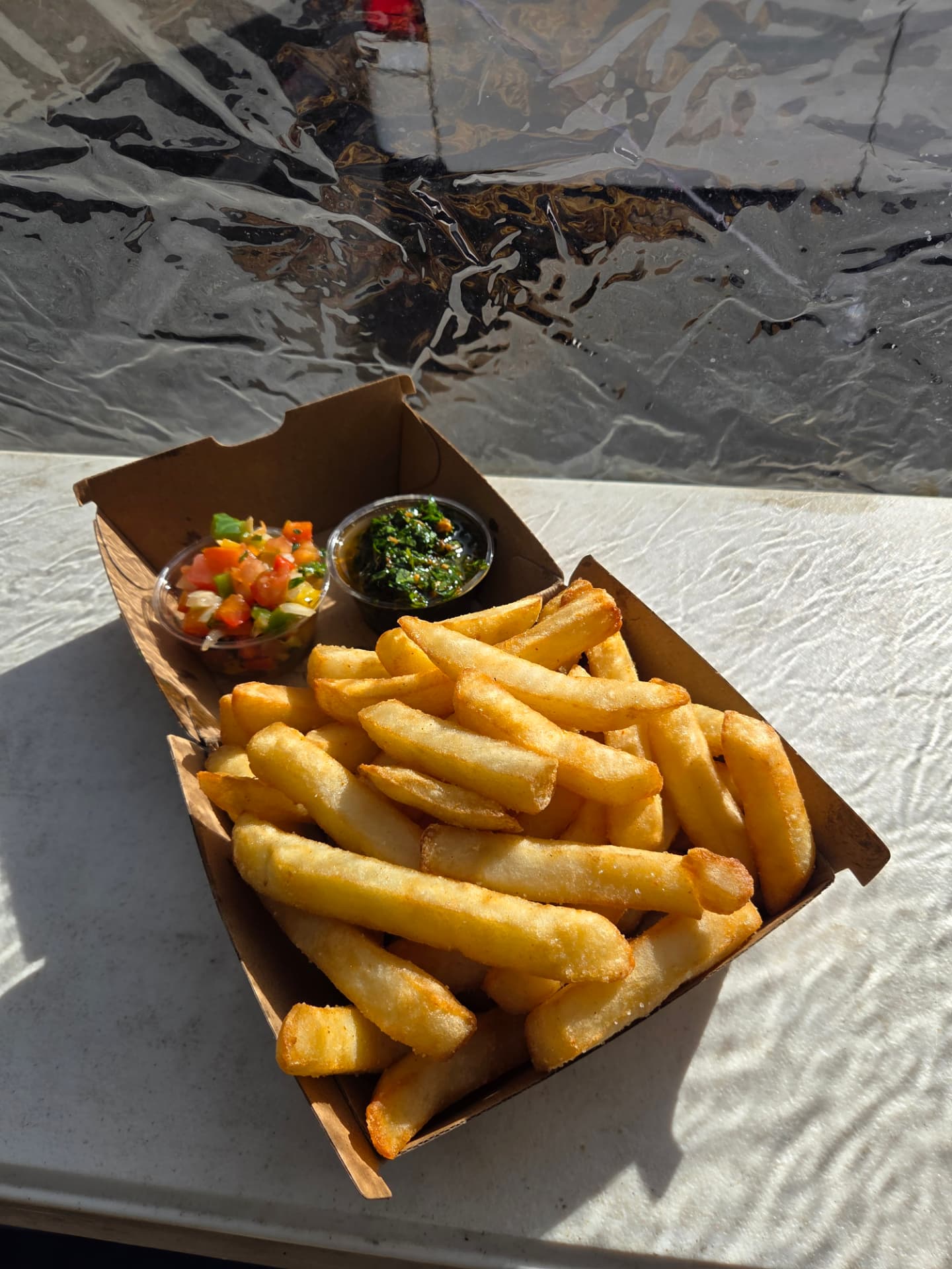 Box of golden chips with salsa criolla and chimichurri